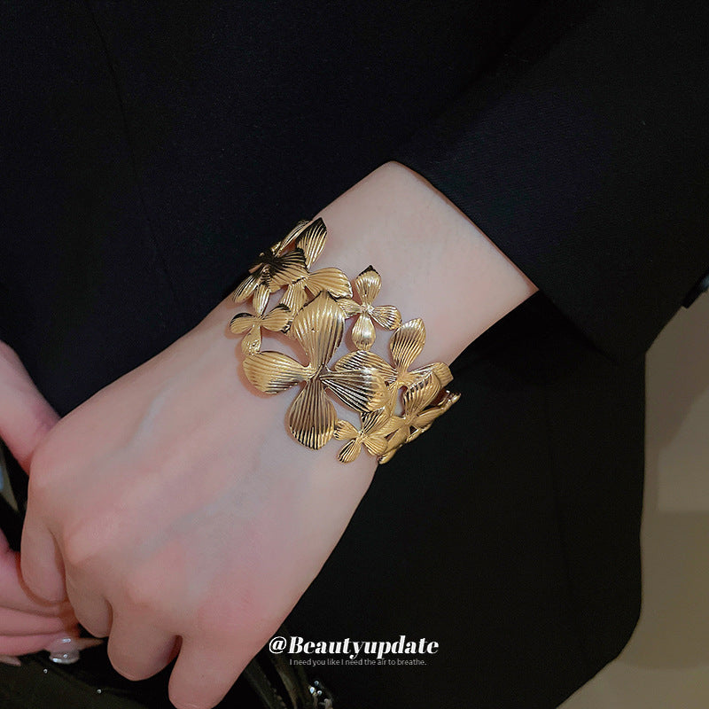 Elegante pulsera de banda ancha calada con forma de flor para mujer con acabado metálico chapado, estilo de oficina a la moda