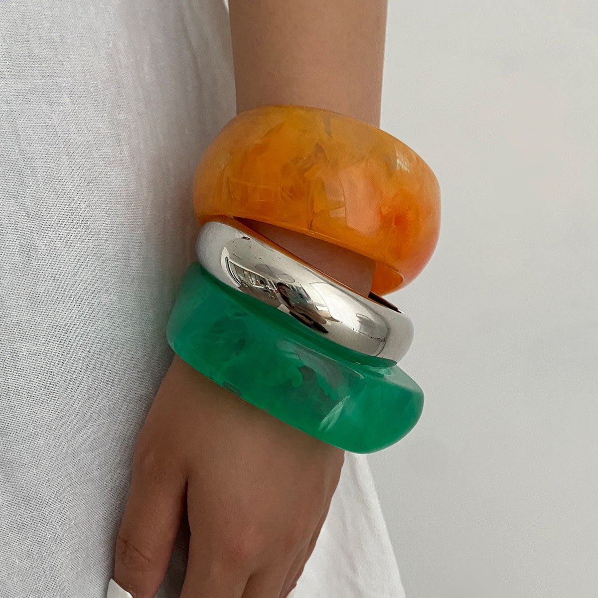 Bracciale minimalista in resina con forme geometriche irregolari, effetto sfumato e finitura placcata