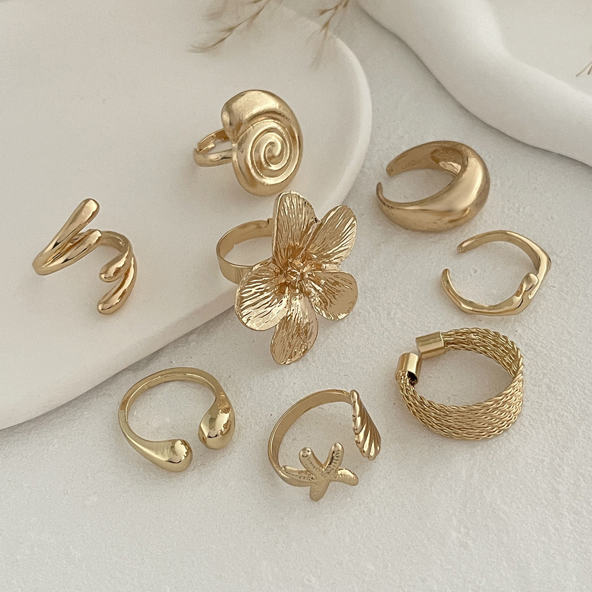 Anello aperto personalizzato con elementi floreali e geometrici, conchiglia e stella