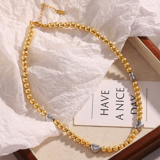 Collar de acero inoxidable minimalista con forma de corazón, chapado en oro de 18 quilates y detalle de cuentas.