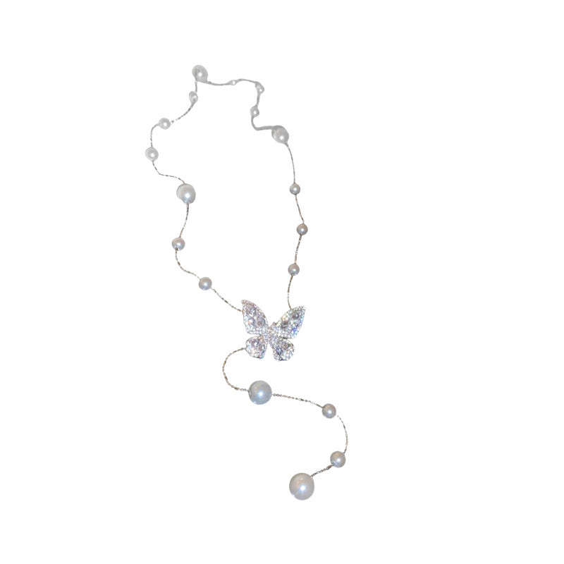Collana con ciondolo a farfalla in zirconi placcato oro, stile dolce e minimalista, con inserti in perle e dettagli sfrangiati da donna