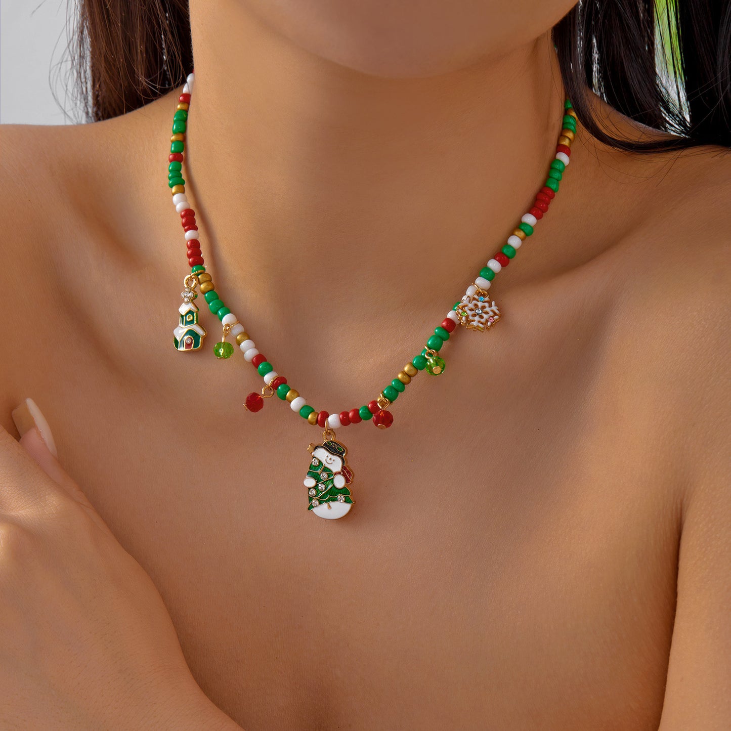 Collana in lega a tema natalizio con ciondolo a forma di Babbo Natale, campanella, casa innevata e fiocco di neve in stile festivo