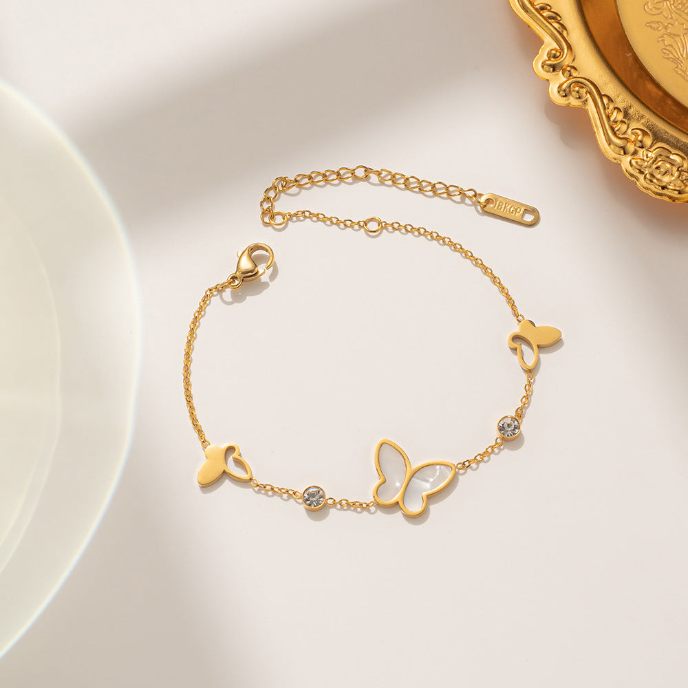 Pulsera minimalista con forma de mariposa de acero de titanio con incrustaciones de nácar y detalles de pedrería, diseño calado con baño de oro para un color duradero