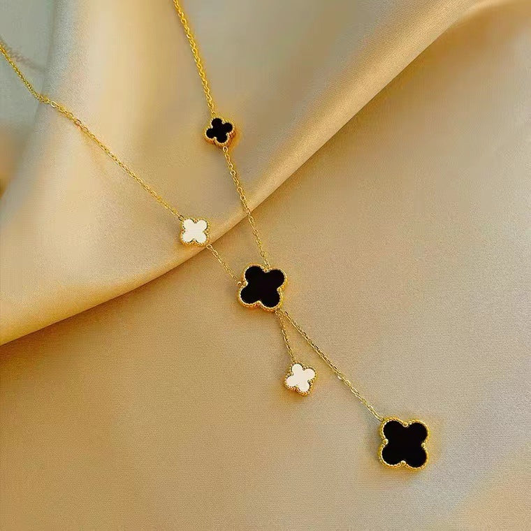 Collana con ciondolo a trifoglio minimalista in acciaio al titanio con placcatura in oro e dettaglio a nappa su catena a O