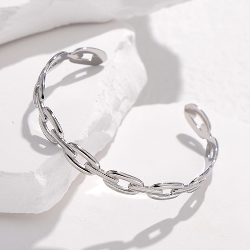 Pulsera Minimalista de Acero de Titanio Abierta para Mujer con Acabado Chapado y Detalle de Cadena