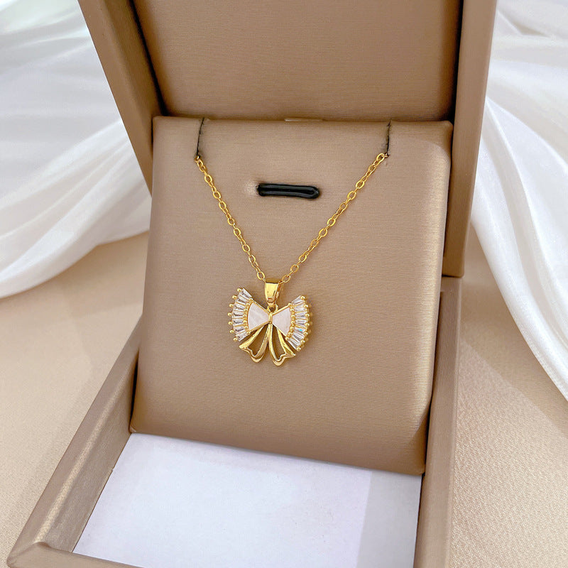 Elegante conjunto de collar y pendientes de acero de titanio con lazo y acabado chapado para mujer