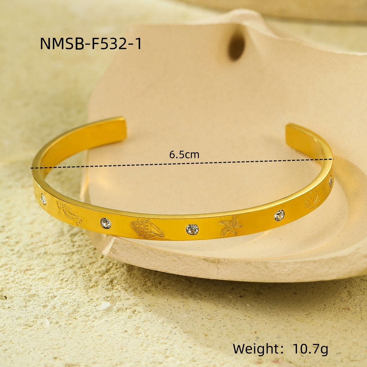 Brazalete abierto de acero de titanio con diseño geométrico, inspirado en el océano, con incrustaciones de pedrería y acabado chapado