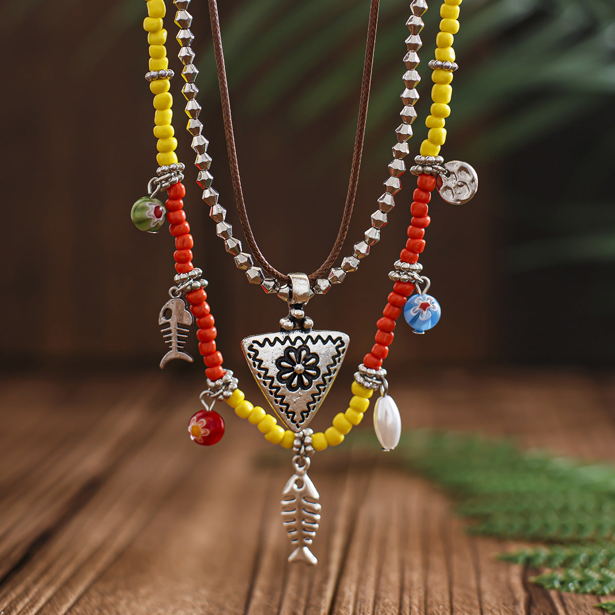 Collana pendente bohémien floreale e geometrica da donna in lega con finitura placcata, nappe e strati di perline