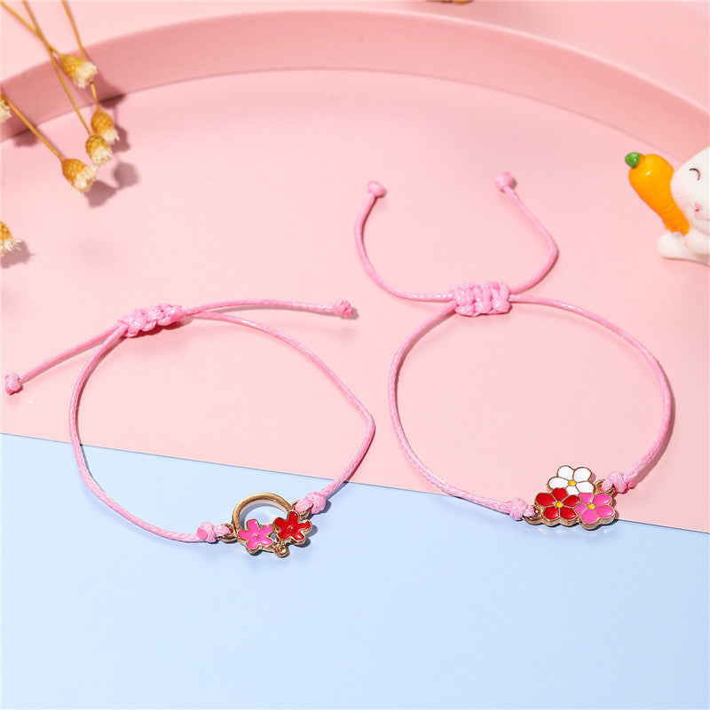 Pulsera infantil de cuerda trenzada con motivo floral y acabado esmaltado en metal de aleación