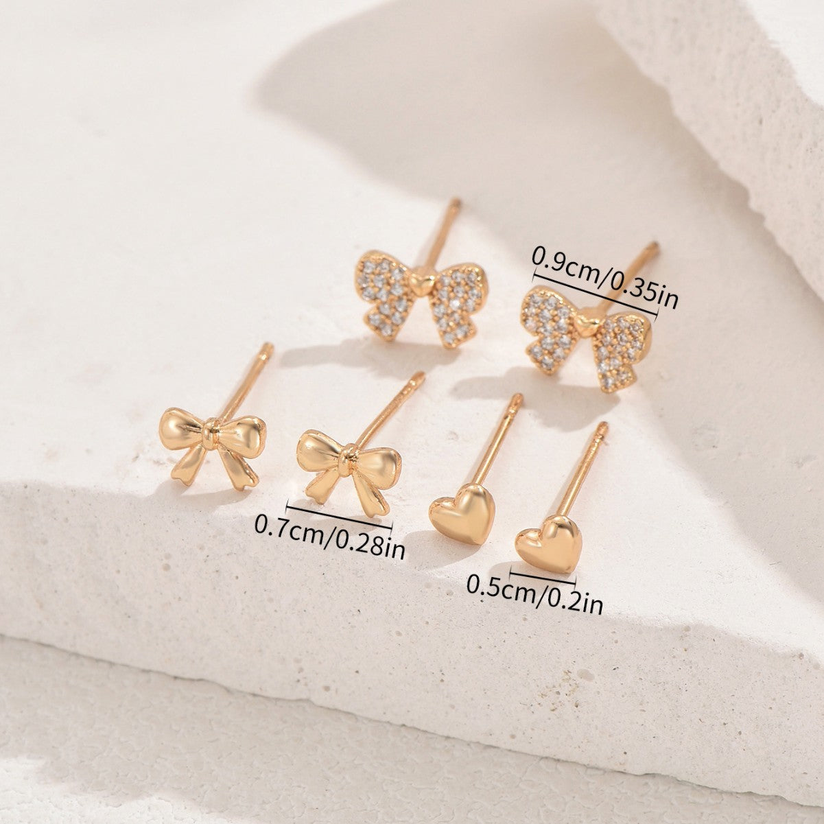 Orecchini a perno da donna minimalisti ispirati a Chanel con forme a cuore e fiocco in rame con intarsio di zirconi, design asimmetrico