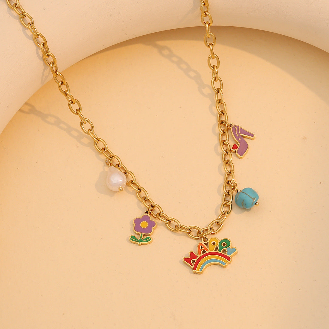 Collana con ciondolo in resina a forma di arcobaleno a cartone animato con accenti floreali turchesi e catena a serpente in acciaio inossidabile da donna