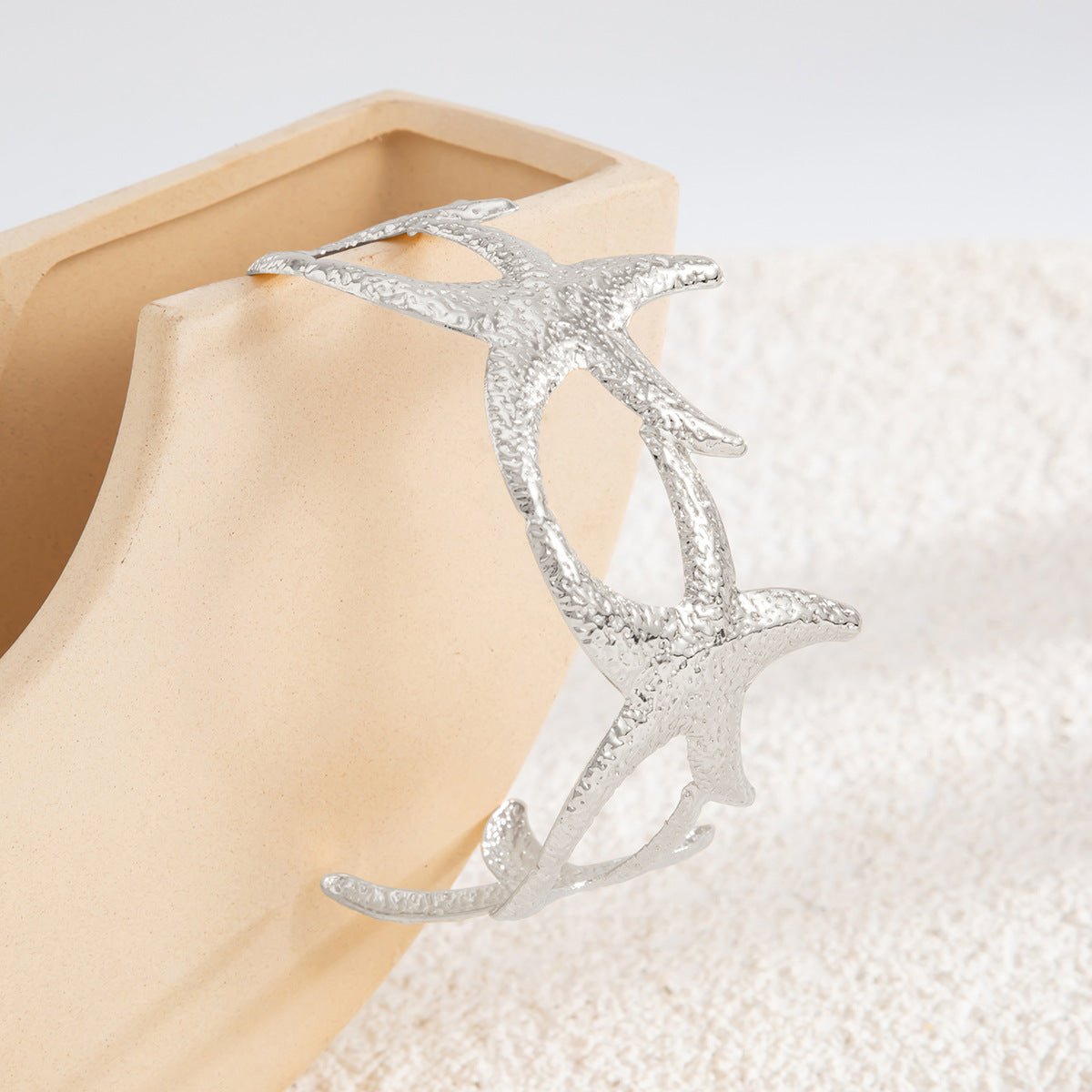 Pulsera rígida abierta con forma de estrella estilo vacaciones en metal chapado con superficie texturizada y diseño inspirado en el océano