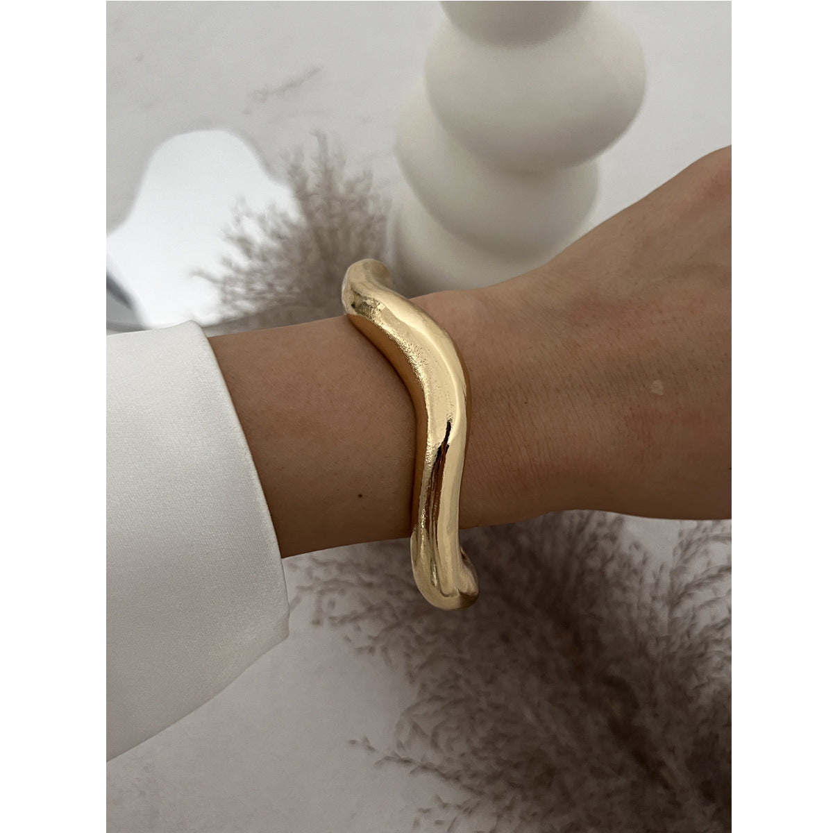 Bracciale rigido da donna in metallo audace con design geometrico, superficie lucida e finitura placcata