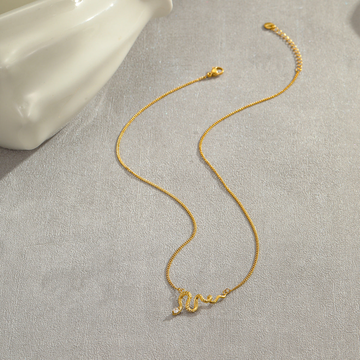 Collar de acero de titanio con forma de serpiente a la moda con incrustaciones de diamantes de imitación y colgante de flecos para mujer