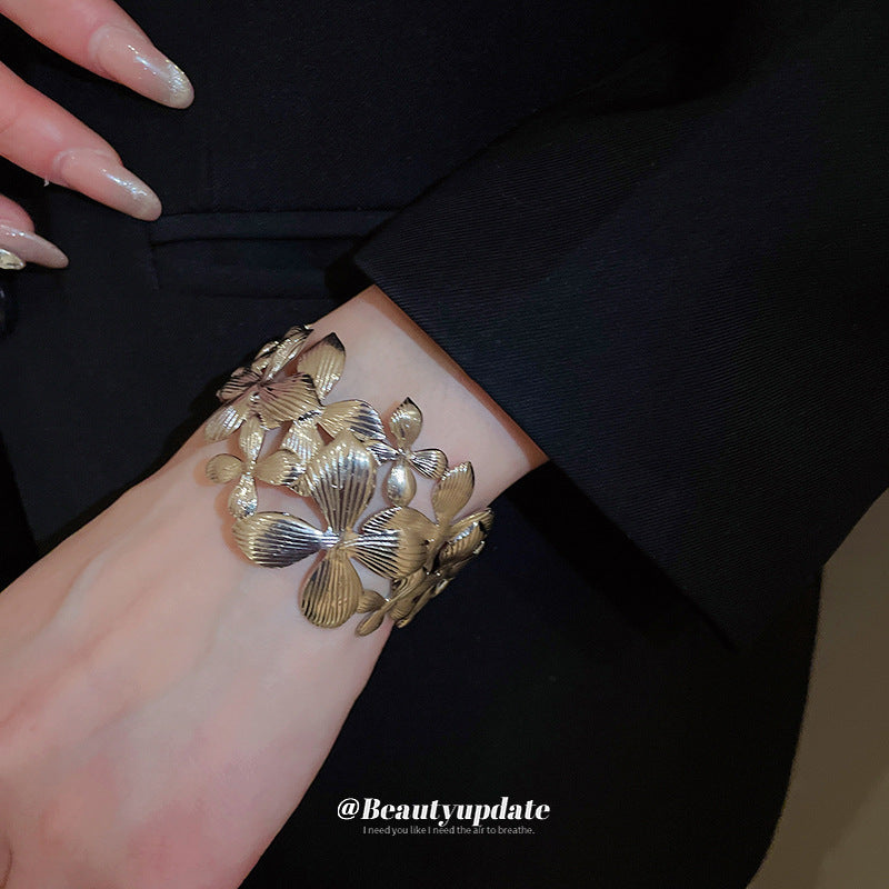 Elegante pulsera de banda ancha calada con forma de flor para mujer con acabado metálico chapado, estilo de oficina a la moda