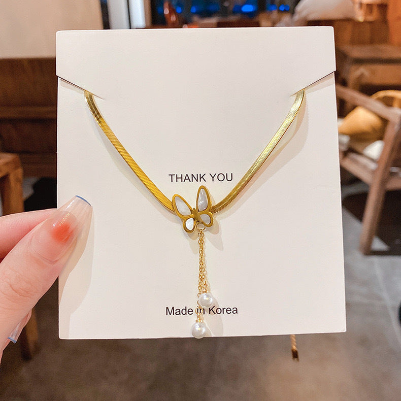 Collana Pendente Minimalista a Forma di Farfalla in Acciaio al Titanio con Accenti di Perle e Nappe per Donna
