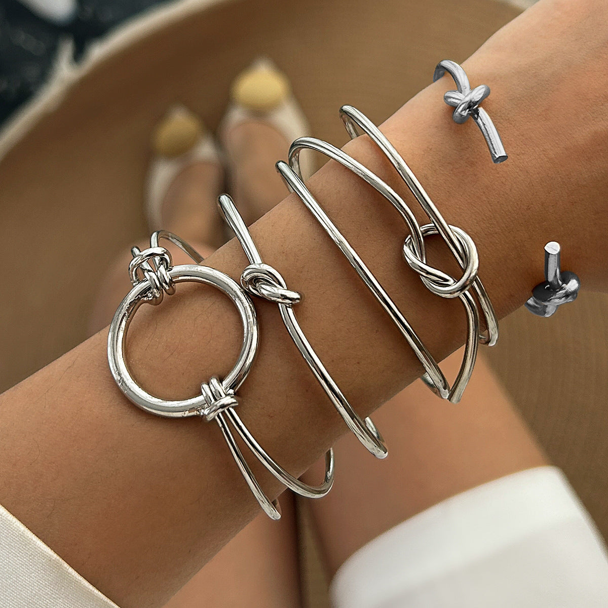 Brazalete abierto geométrico minimalista de doble capa con nudo hueco y acabado metálico chapado