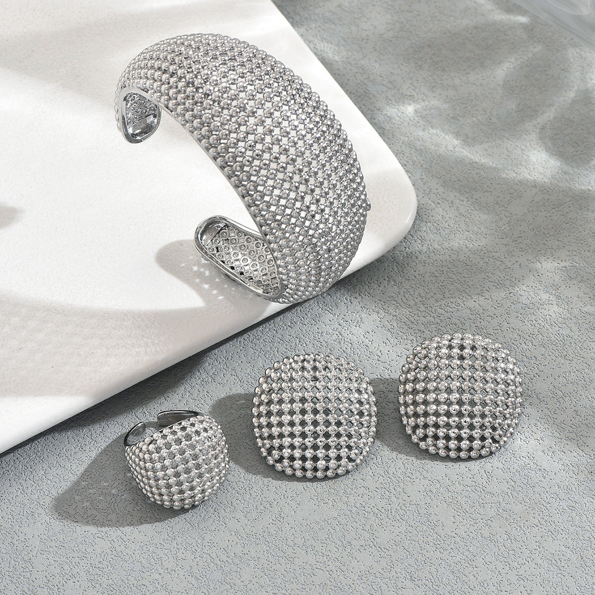 Set di gioielli placcati in lega di zinco con bracciale, orecchini e anello a forma geometrica traforata da donna