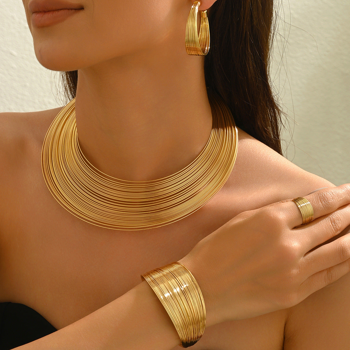 Conjunto de collar de metal multicapa con diseño de líneas geométricas, pulsera ajustable y pendientes para mujer