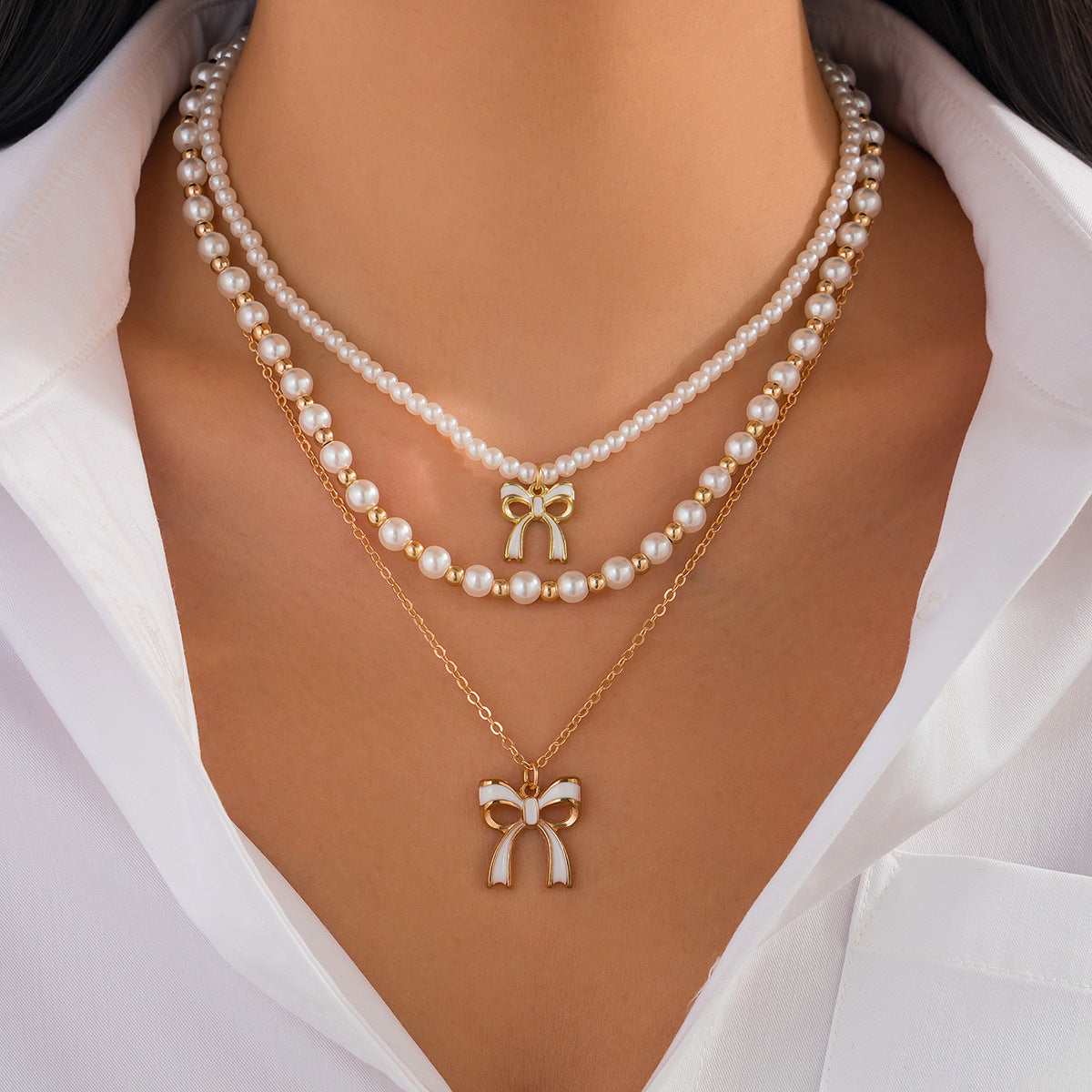 Graziosa collana pendente a forma di fiocco con dettaglio nappa, perla sintetica e lega, finitura placcata, stile a strati da donna