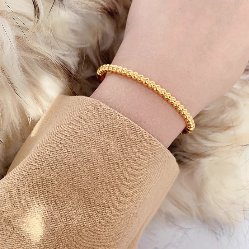 Bracciale minimalista da donna in acciaio al titanio color oro con perline rotonde lucide