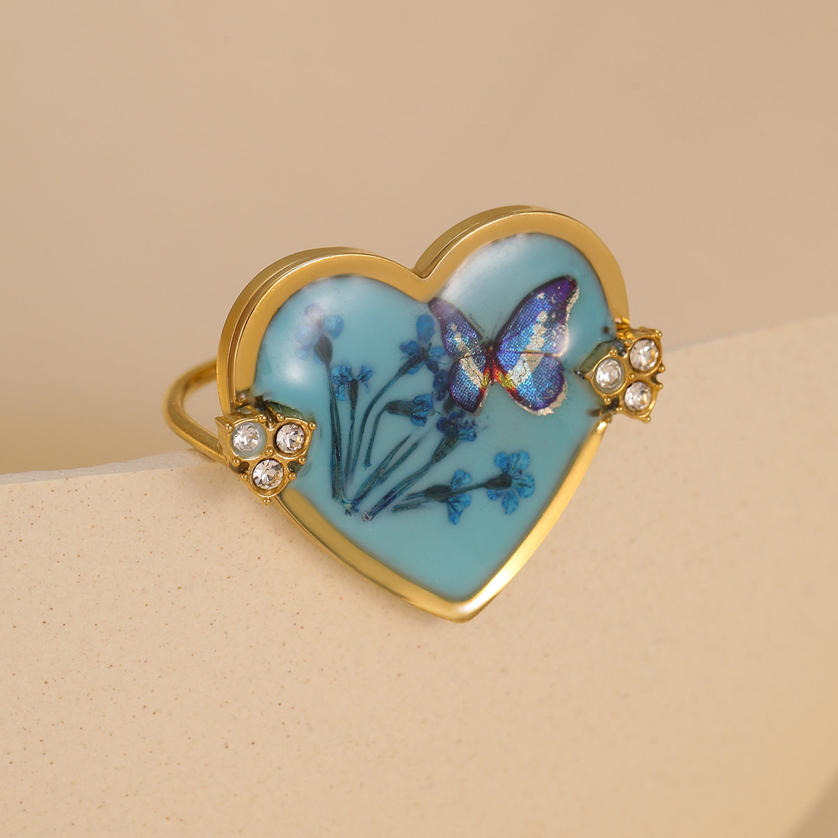Elegante anillo de acero inoxidable con forma de corazón, lazo de resina y detalles de flores prensadas, incrustaciones de pedrería, acabado chapado para mujer