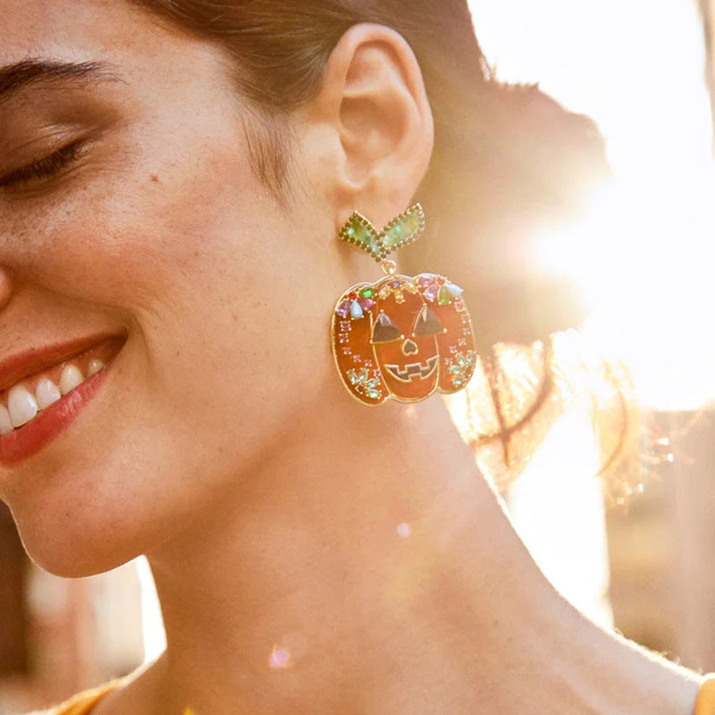 Elegantes aretes de calavera de Halloween con detalles de diamantes de imitación en aleación de zinc, con motivos de brujas, calabazas y murciélagos.