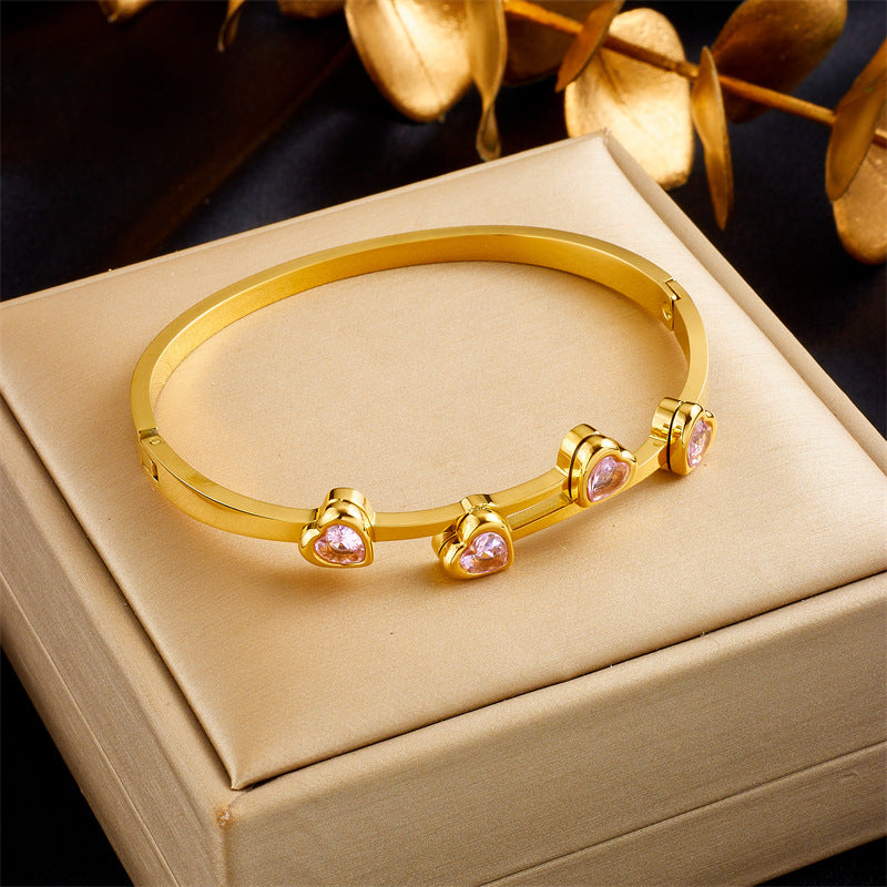 Elegante pulsera de titanio chapado en oro con circonitas en forma de corazón para mujer