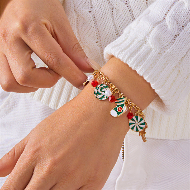 Bracciale artigianale in lega a tema natalizio con ciondolo a forma di Babbo Natale e albero di Natale, perline color caramella, accenti di perle e motivi a fiocco di neve festivi