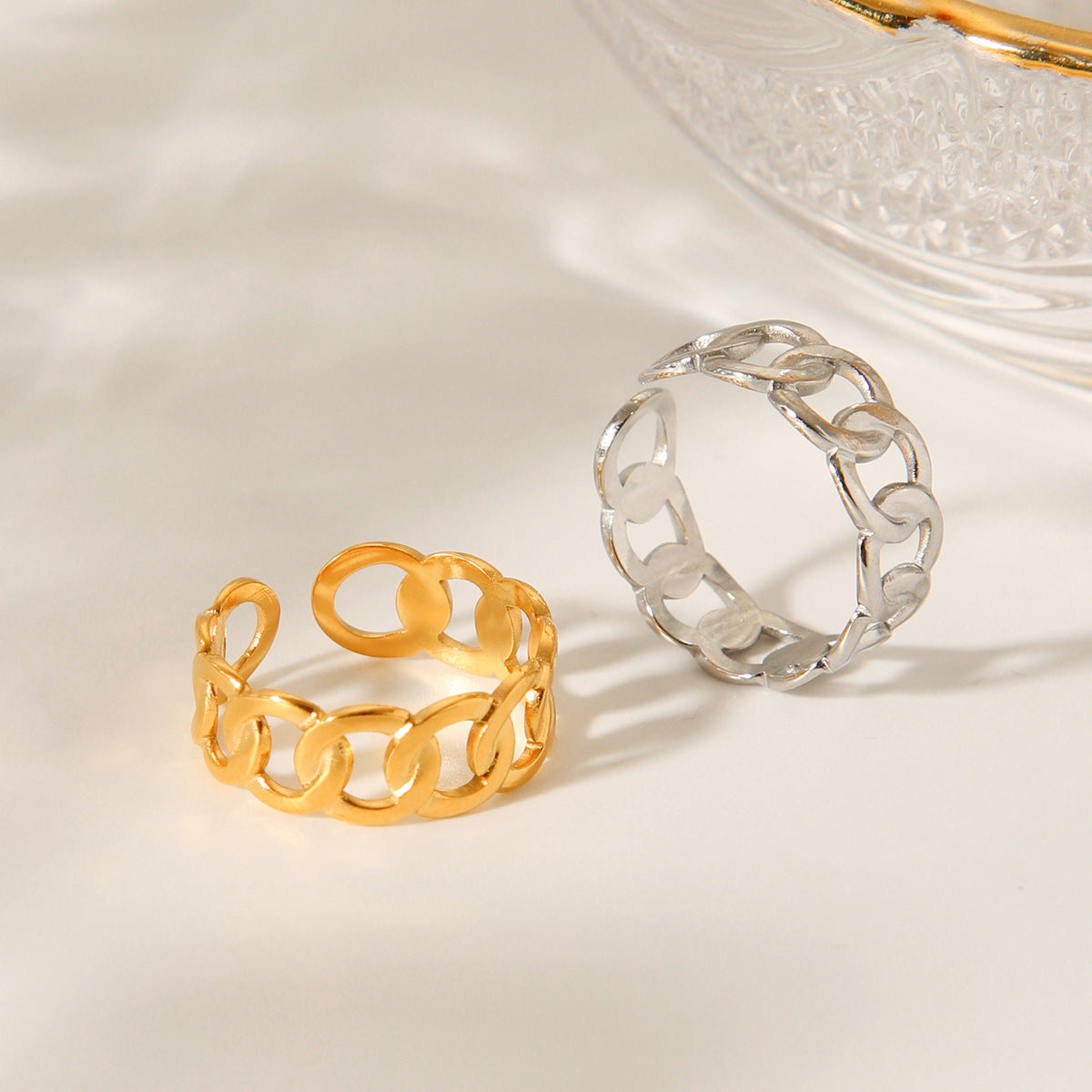 Anello aperto geometrico d'ispirazione per donna in acciaio inossidabile con finitura placcata e dettaglio a catena