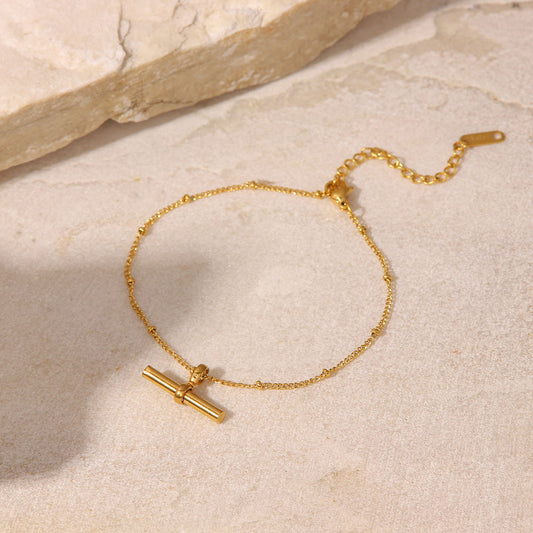 Cavigliera minimalista geometrica in acciaio al titanio con pendente a T placcato oro 18K e catena di perline