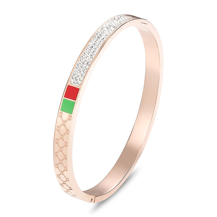 Pulsera minimalista de acero de titanio con incrustaciones de pedrería roja y verde, bañada en oro rosa para mujer