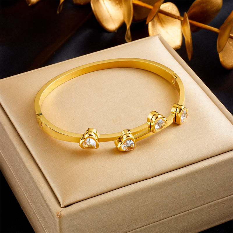 Elegante pulsera de titanio chapado en oro con circonitas en forma de corazón para mujer