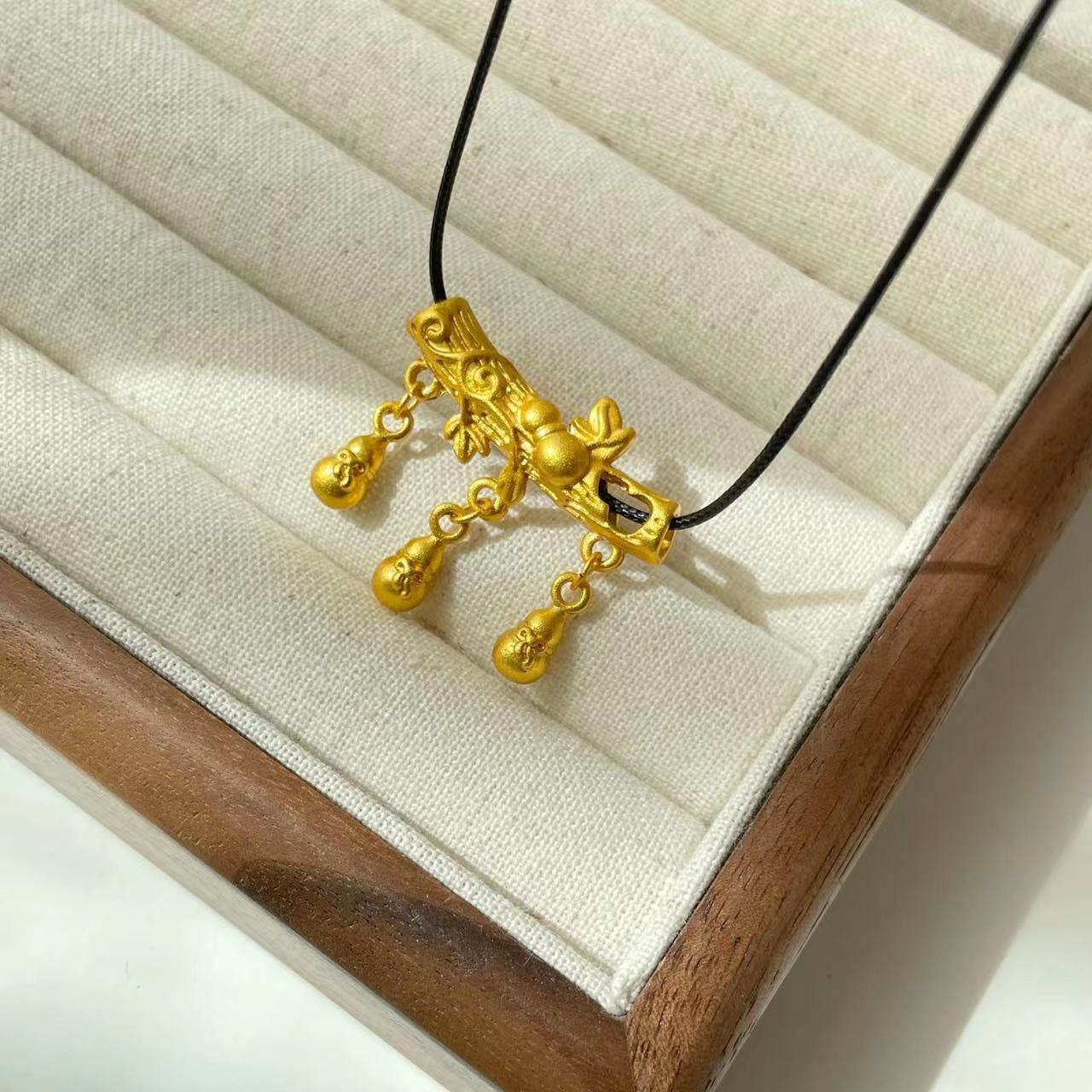 Collana con ciondolo a baccello di loto e zucca in stile etnico da donna con charm in rame placcato oro, dettaglio nappa, catena in cordino nero