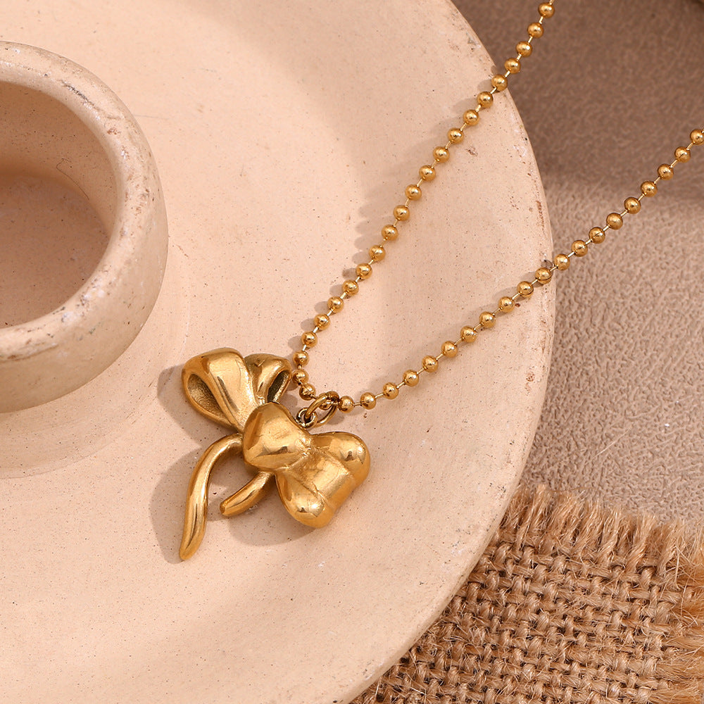 Collana con ciondolo a fiocco alla moda da donna in acciaio inossidabile con placcatura in oro 18 carati su catena di perline rotonde