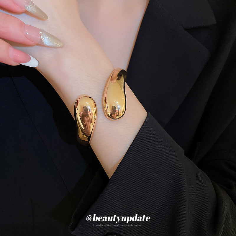 Bracciale rigido minimalista in metallo regolabile da donna con finitura placcata e sottile accento a goccia