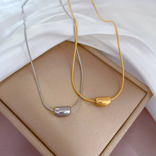 Collana con ciondolo geometrico in stile cartone animato da donna in acciaio al titanio placcato oro, design a catena clavicolare con motivo a fagiolo rosso