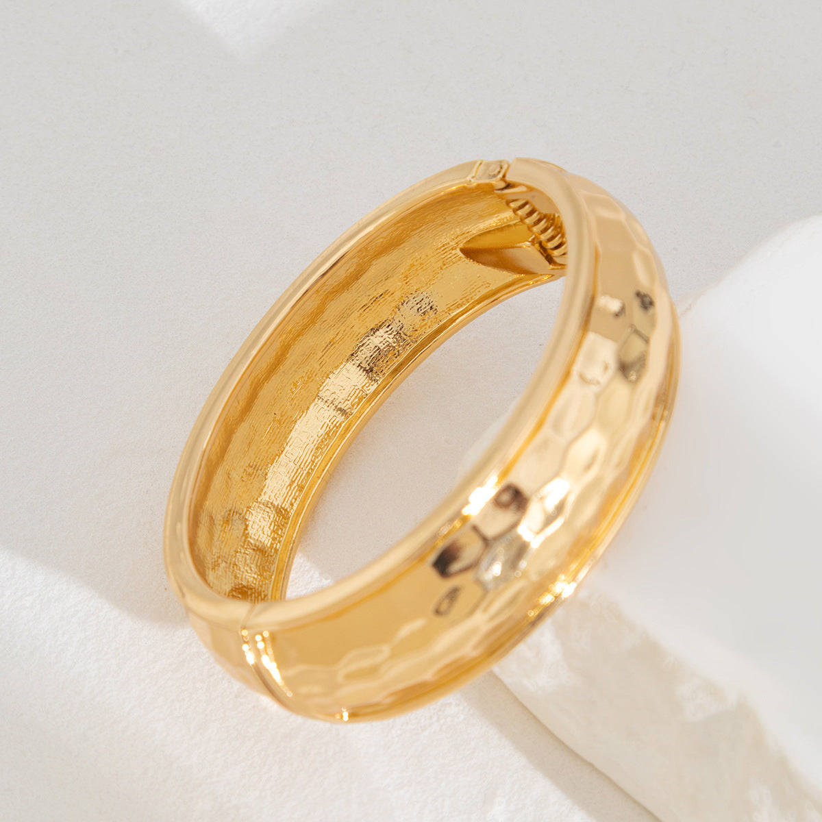 Bracciale rigido aperto da donna minimalista geometrico con texture martellata e chiusura a molla