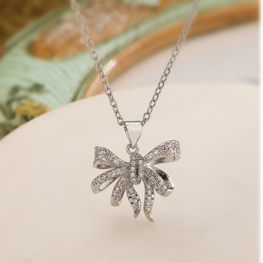 Collana a pendente minimalista in rame a forma di fiocco con placcatura in oro vero e accenti di zirconi per donna