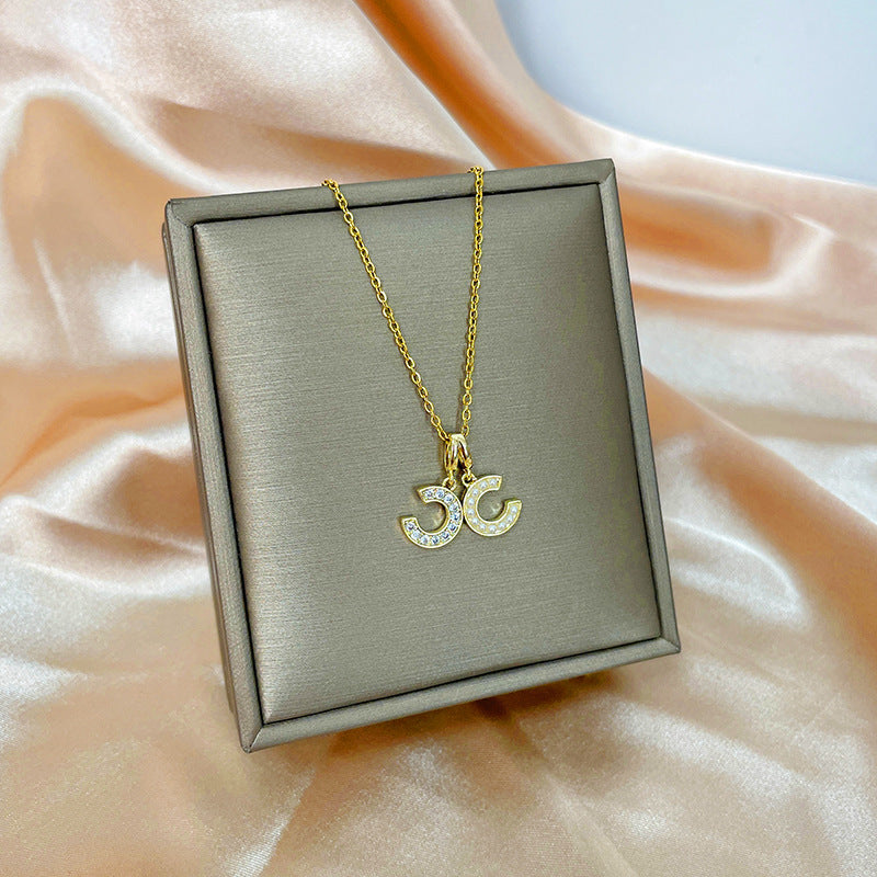 Collana con ciondolo girevole a quadrifoglio in acciaio al titanio con zirconi micropavé da donna