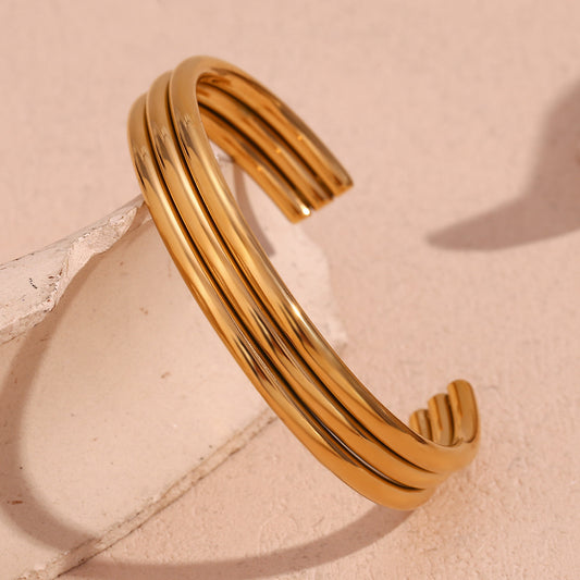 Pulsera Minimalista de Acero Inoxidable Pulido con Triple Tubo Abierto y Baño de Oro de 18K para Mujer