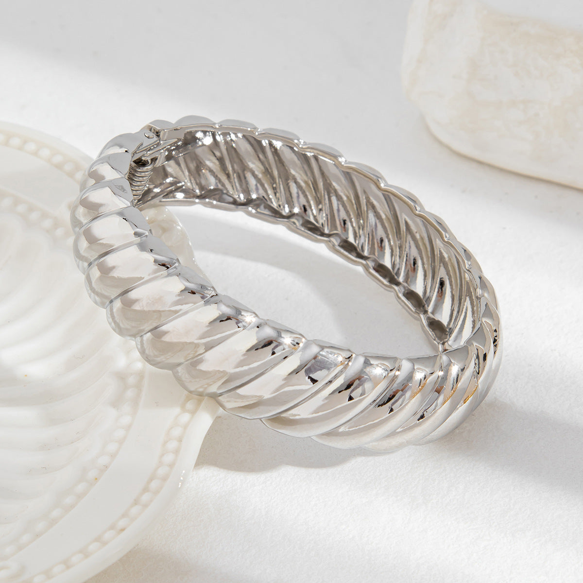 Bracciale minimalista in lega geometrica con finitura lucida e chiusura a molla con texture filettata
