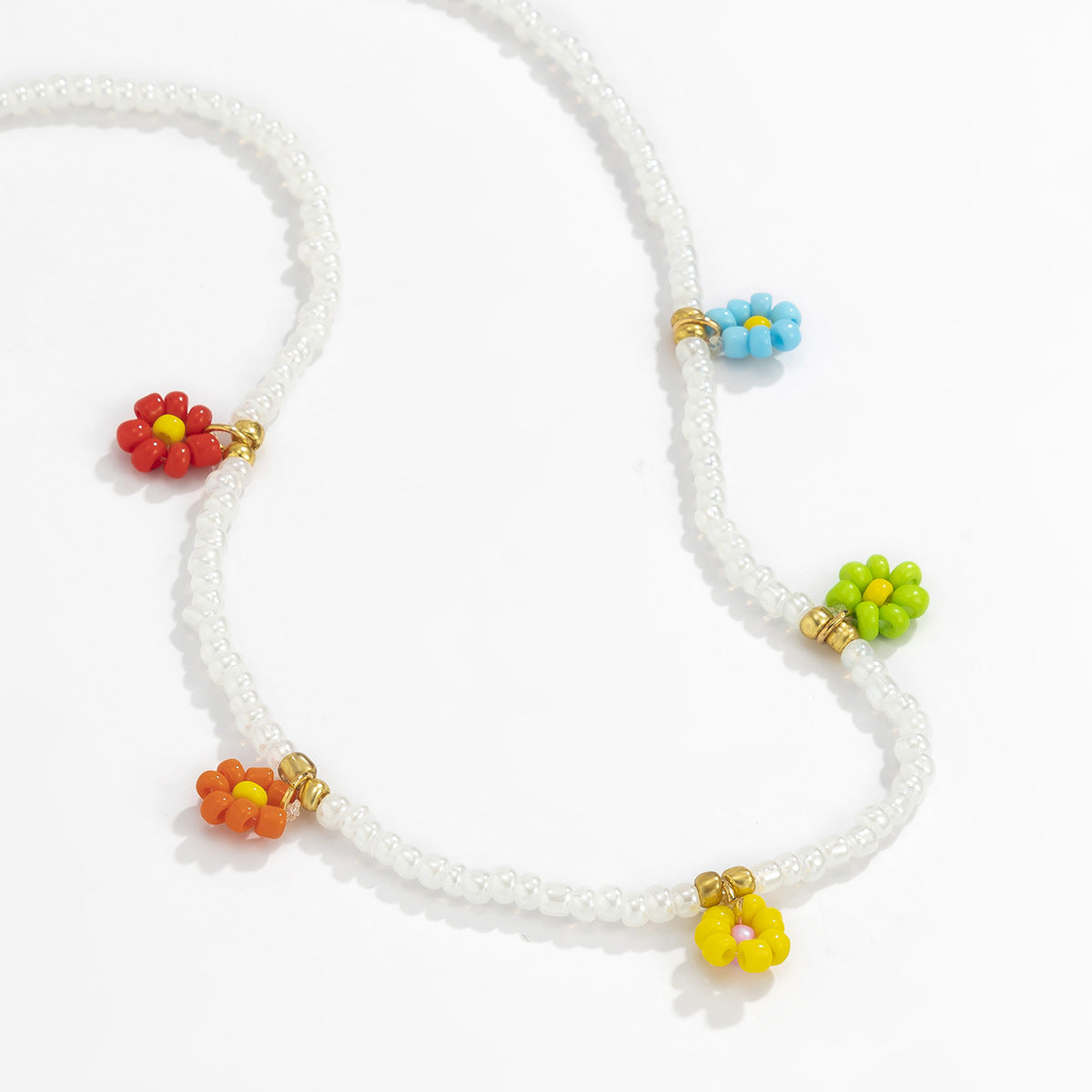 Collana pendente margherita minimalista con dettaglio nappa da donna, con accenti in resina e perline, design floreale rotondo su catena a sfere