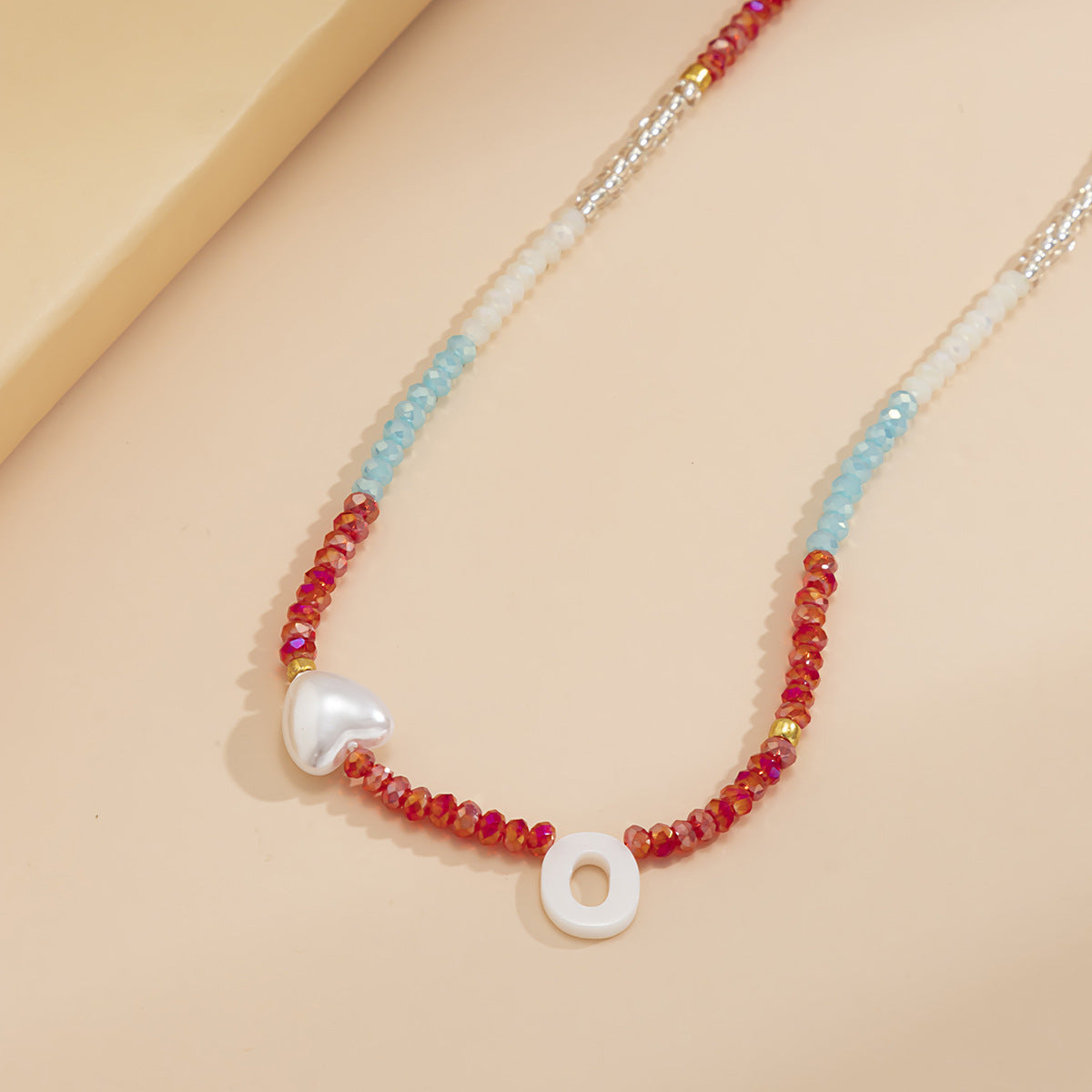 Collana con lettera O in stile bohémien con ciondolo a conchiglia e motivo a cuore geometrico in resina plastica