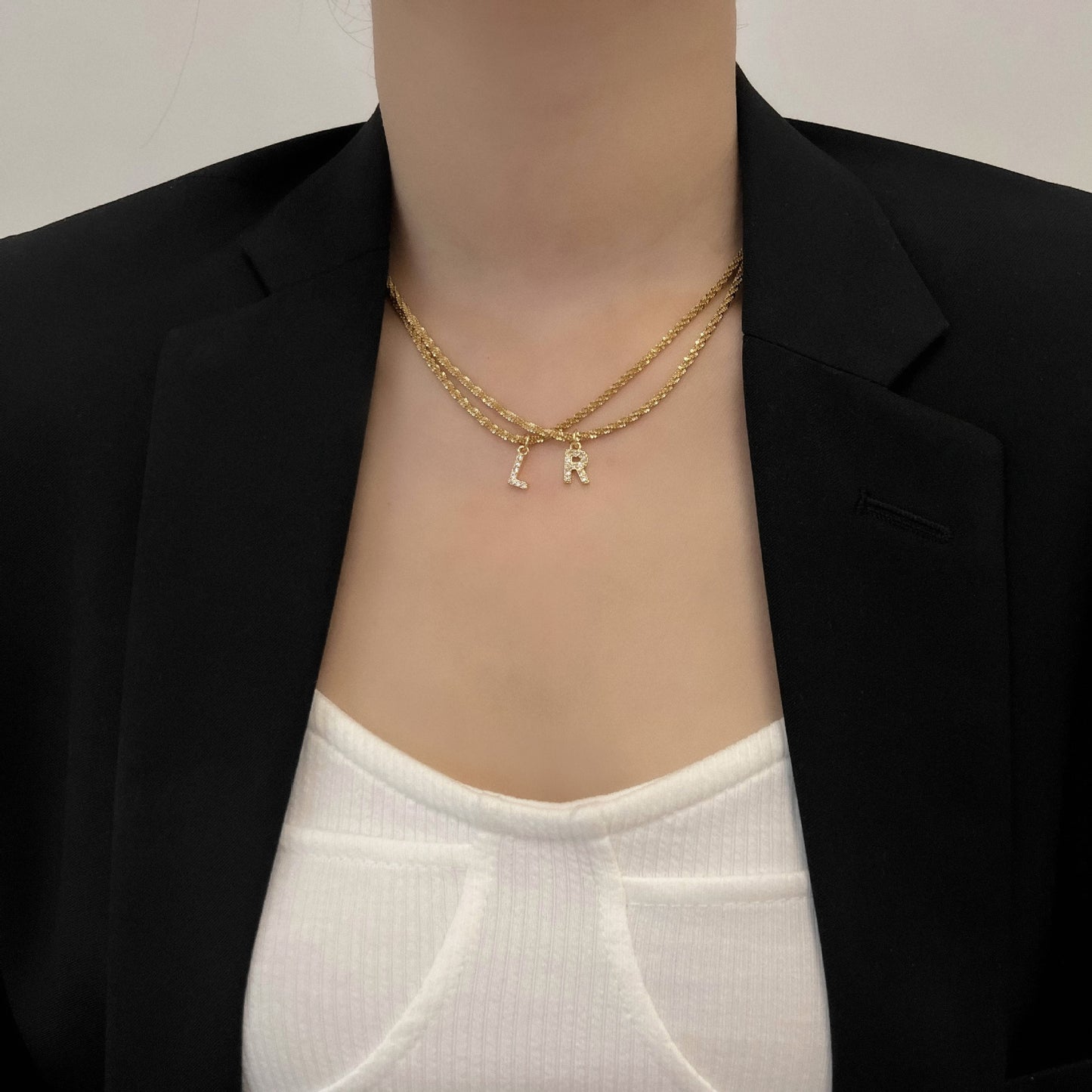 Collana da Donna Minimalista a Forma di Lettera in Acciaio al Titanio con Zirconi Intarsiati e Catena Ondulata