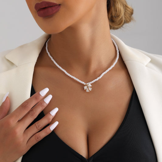 Elegante collar de clavícula con nudo de lazo de inspiración francesa para mujer con colgante de perla simulada y herrajes de aleación chapados en oro