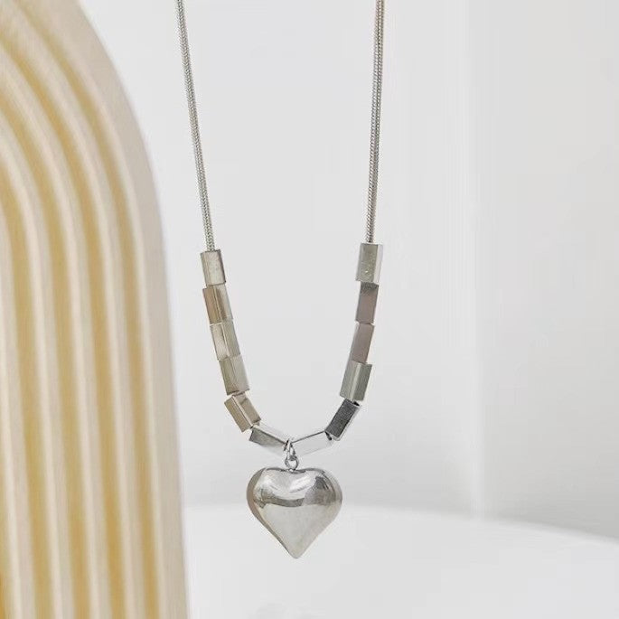 Collana girocollo con ciondolo a cuore geometrico minimalista per donna, in acciaio al titanio con catena a serpente