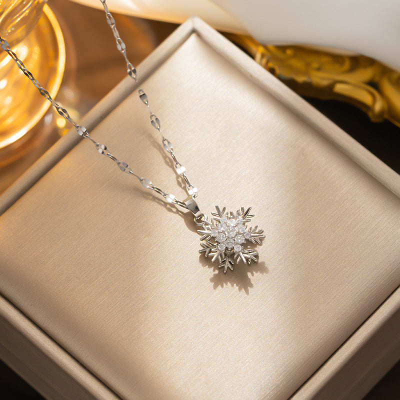 Collana con ciondolo a fiocco di neve girevole da donna in acciaio al titanio con intarsio di strass su catena ondulata