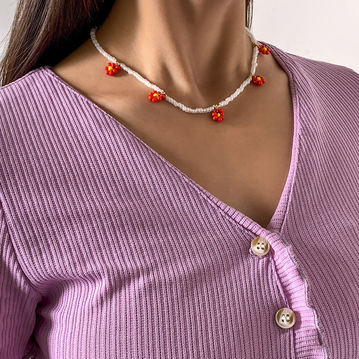 Collana pendente margherita minimalista con dettaglio nappa da donna, con accenti in resina e perline, design floreale rotondo su catena a sfere