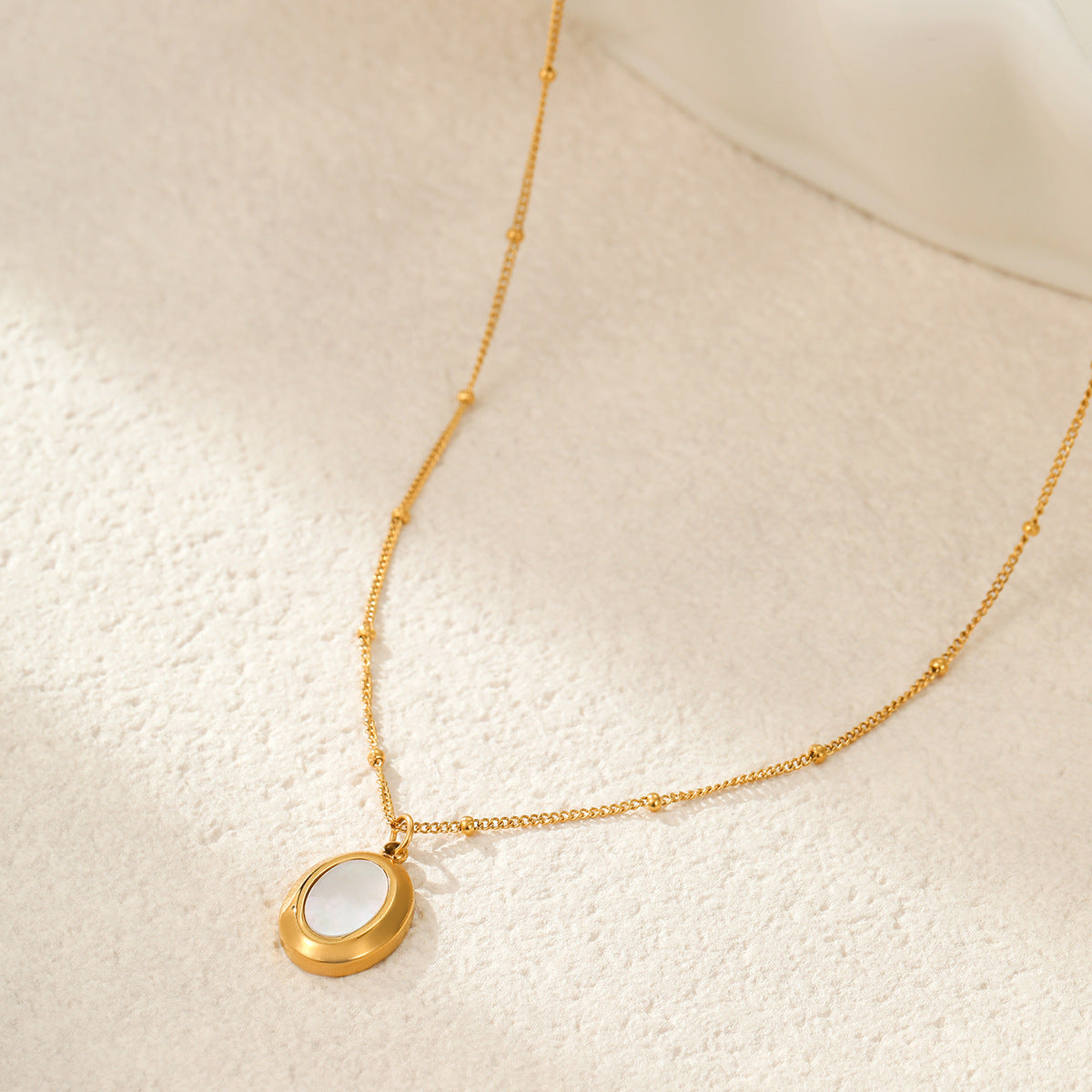 Collar con colgante ovalado geométrico minimalista de abulón blanco en acero de titanio con acabado chapado para mujer